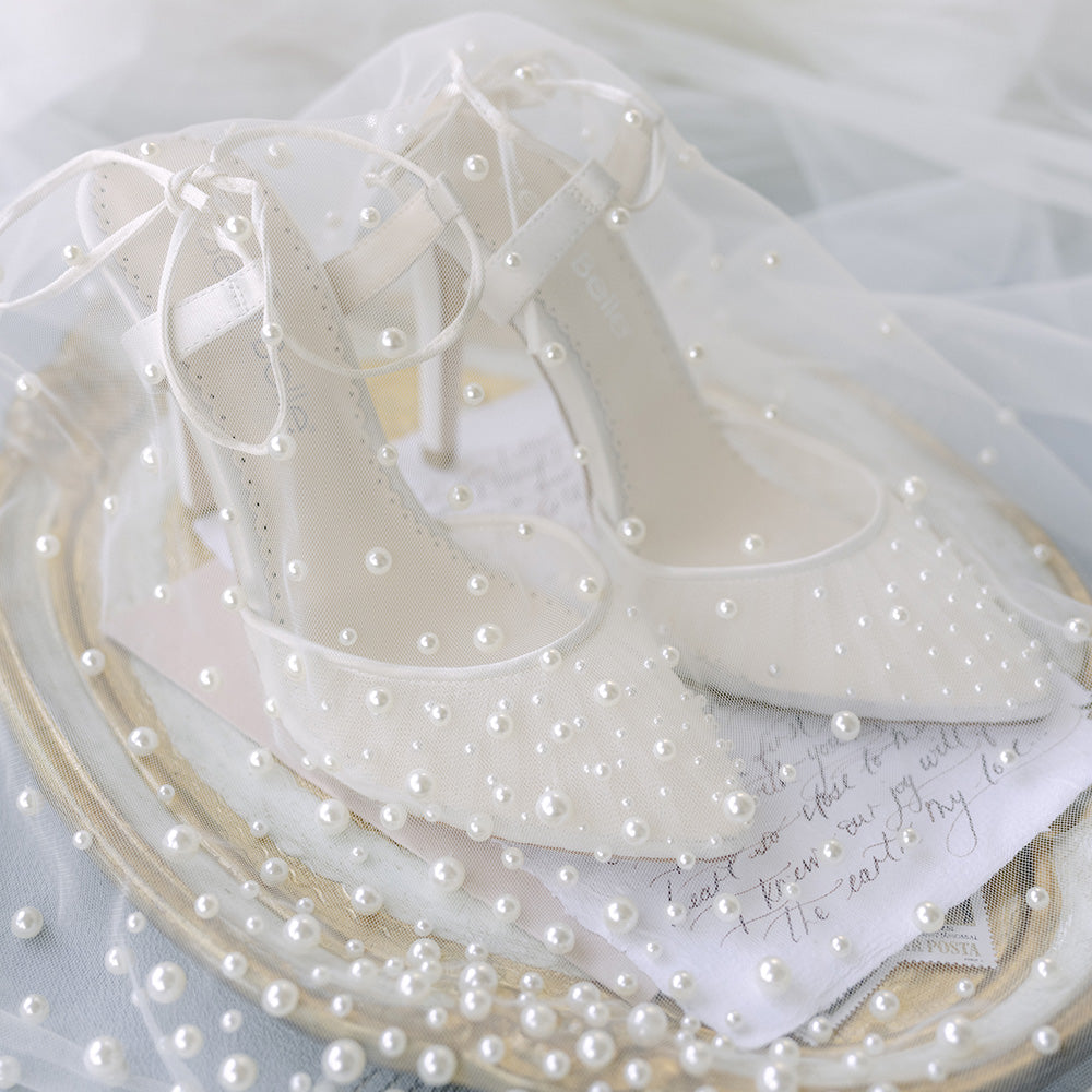 White slingback bridal stillettos styled with pearl scattered veil and love letter