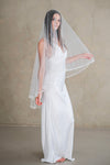 Model wears a wedding veil, drop veil with pearls and sequins