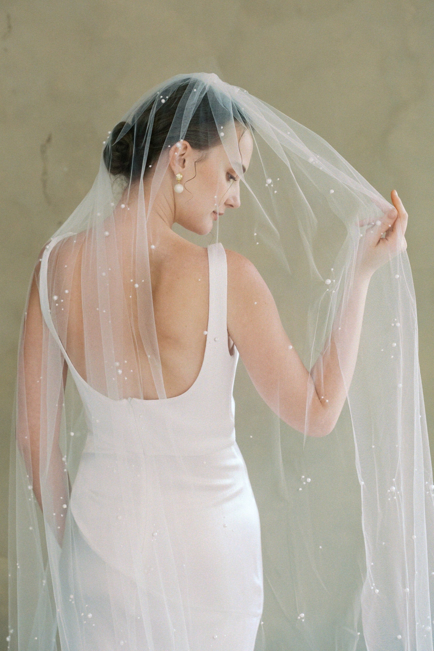 Model wears a one tier pearl wedding veil made by Madame Tulle bridal