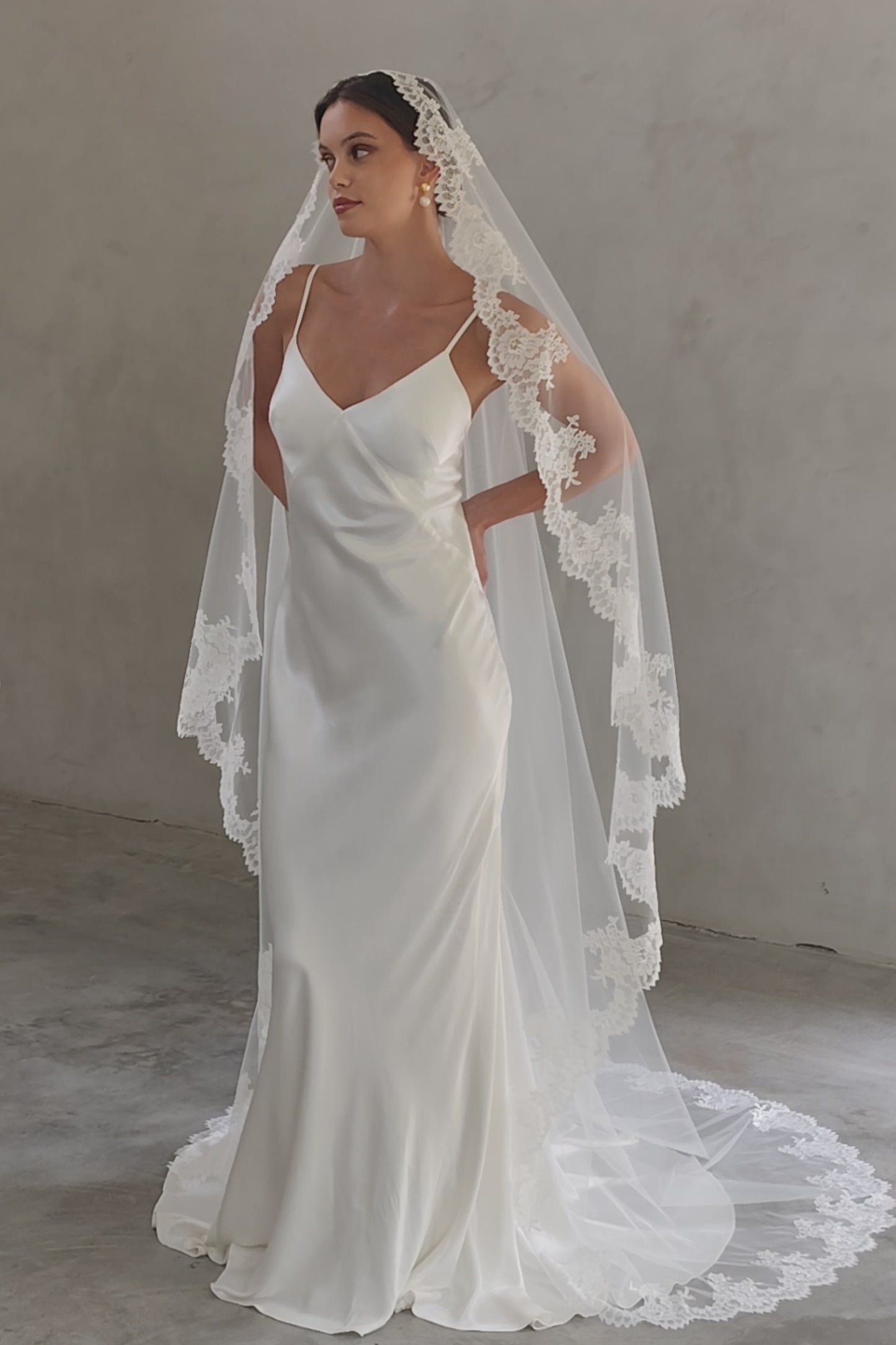 Full length shot of bride wearing long, mantilla veil with lace trim
