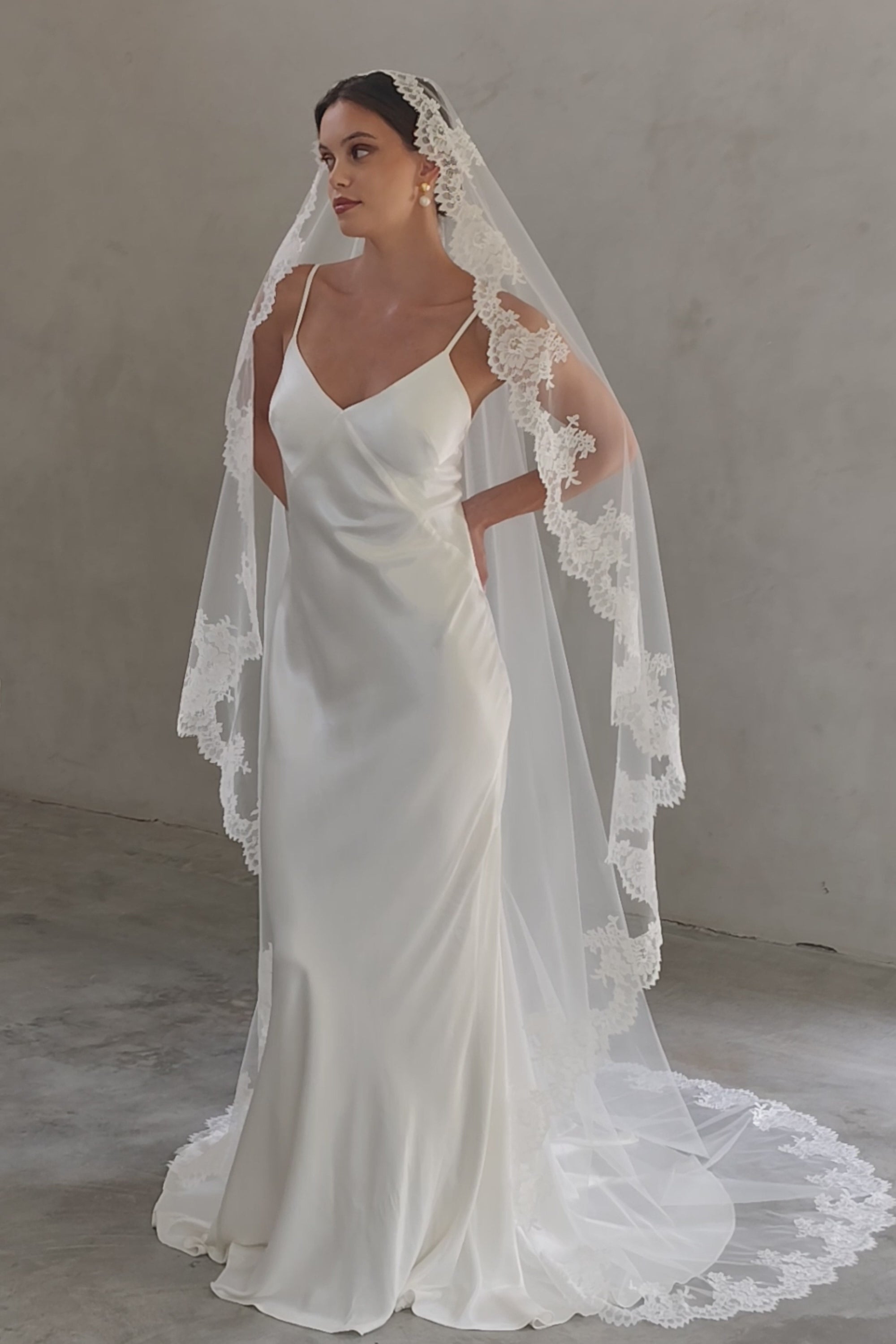 Full length shot of bride wearing long, mantilla veil with lace trim