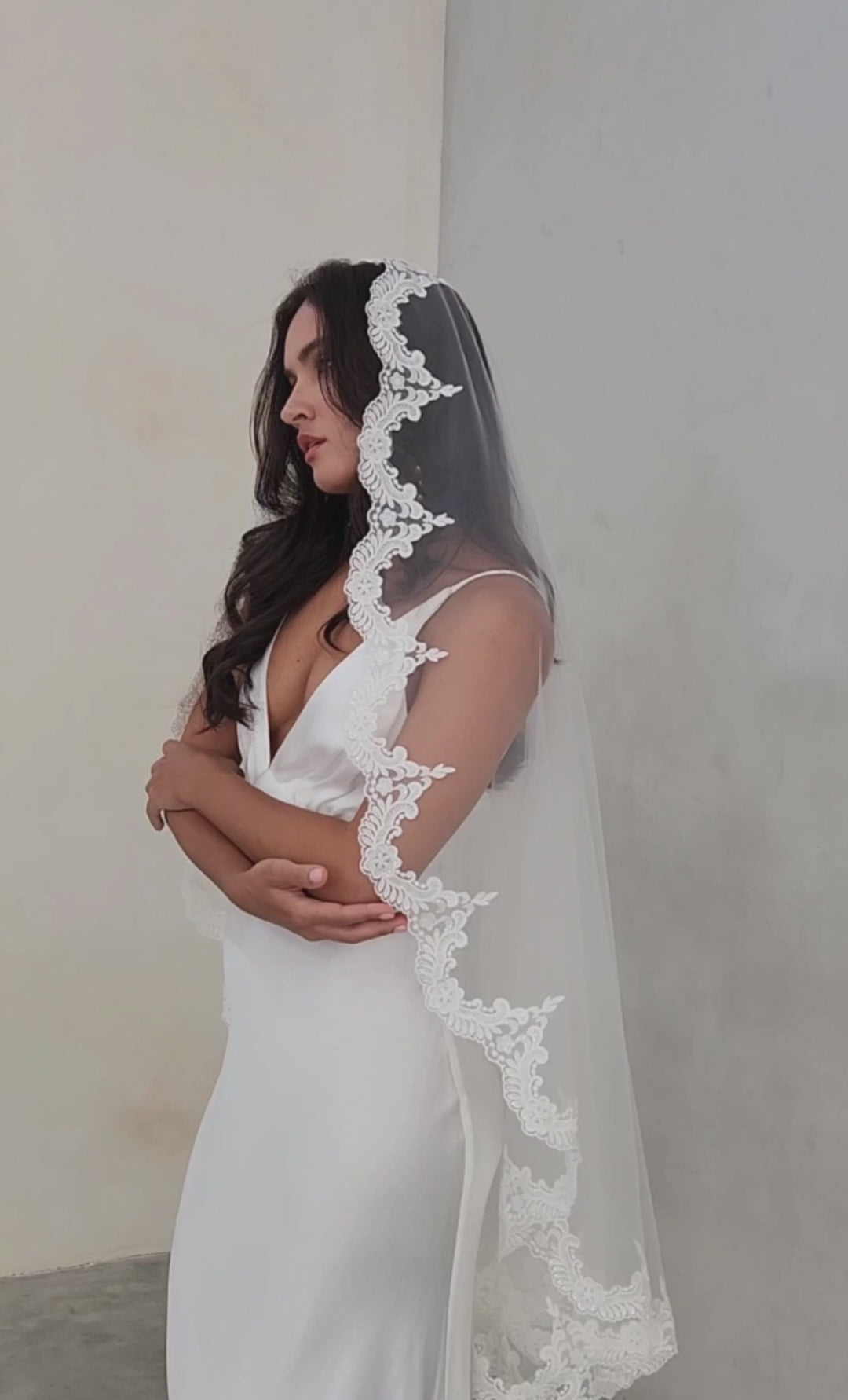 model wears mantilla veil, one-tier lace trim wedding veil