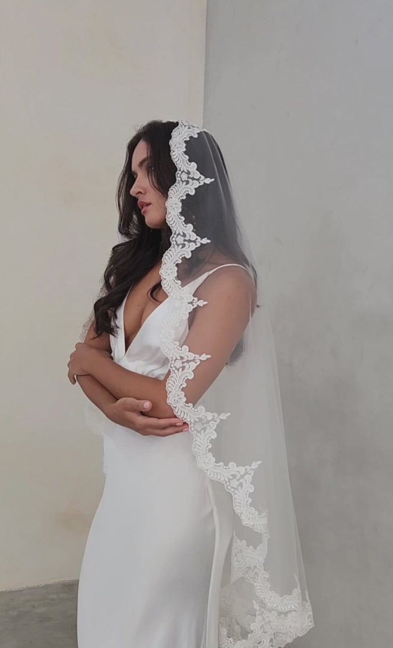model wears mantilla veil, one-tier lace trim wedding veil