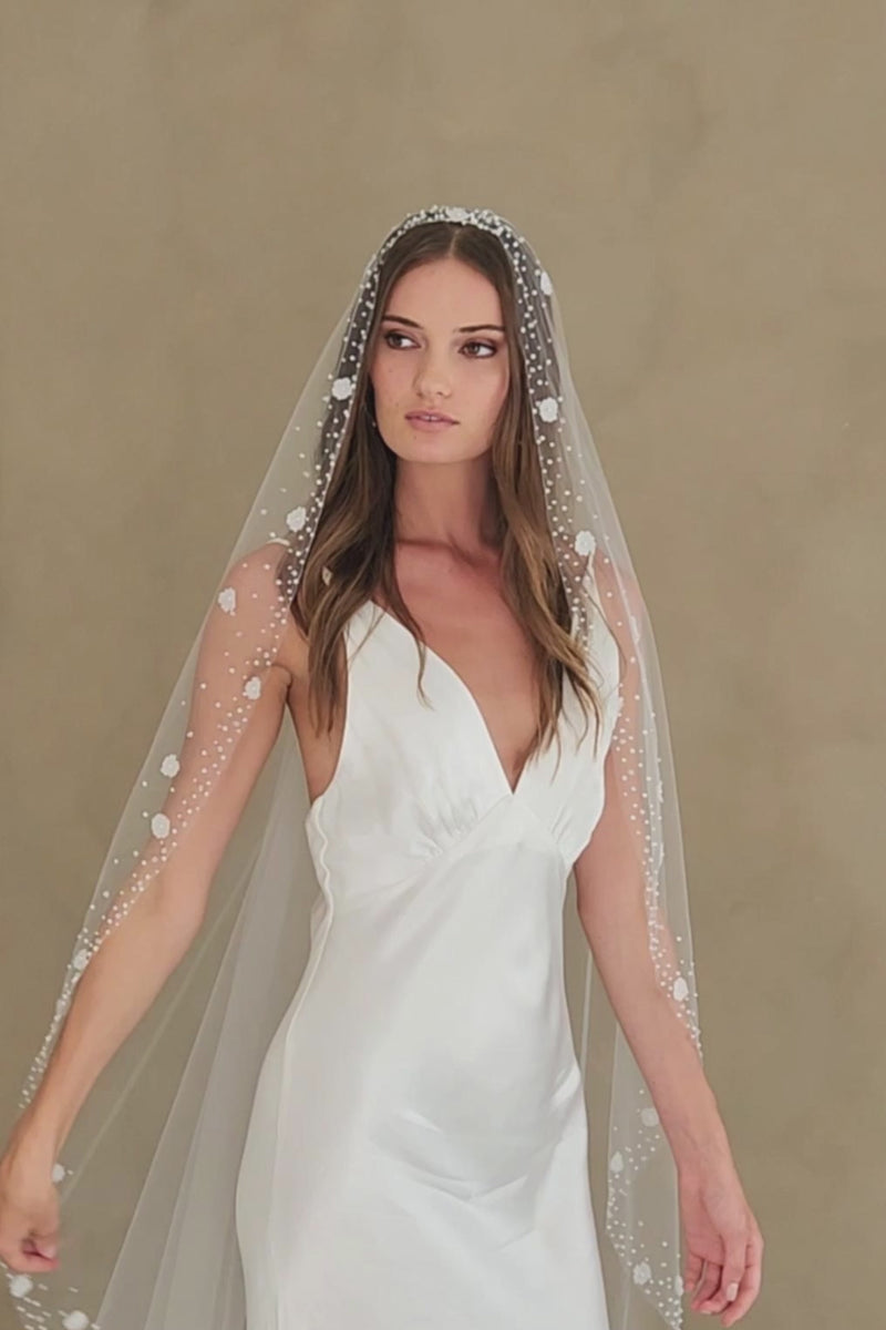 Model wears a floral wedding veil, one tier veil with pearls and fabric flowers.