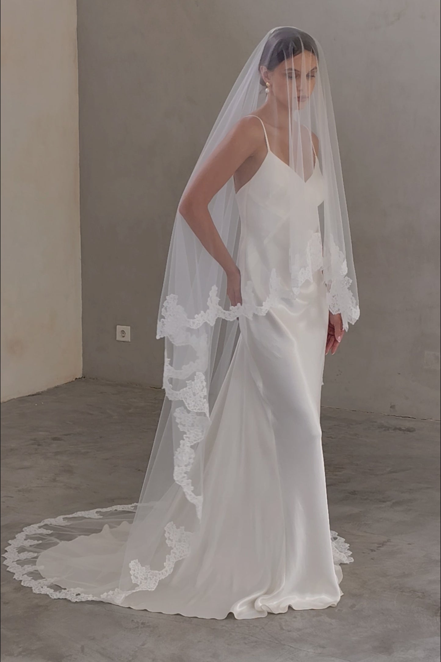 Full length view of bride wearing chapel length modern wedding veil - lace edged, blusher down