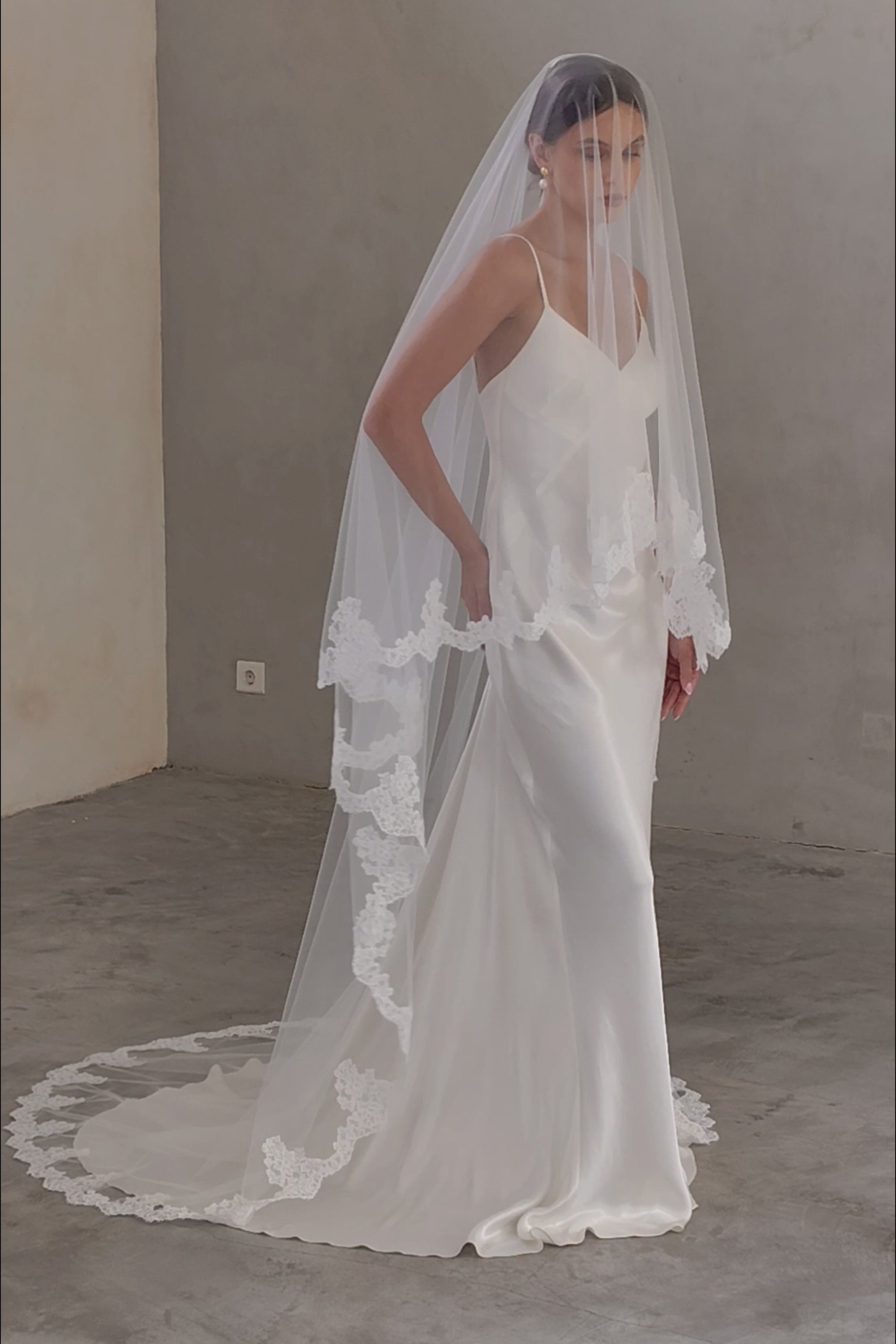 Full length view of bride wearing chapel length modern wedding veil - lace edged, blusher down