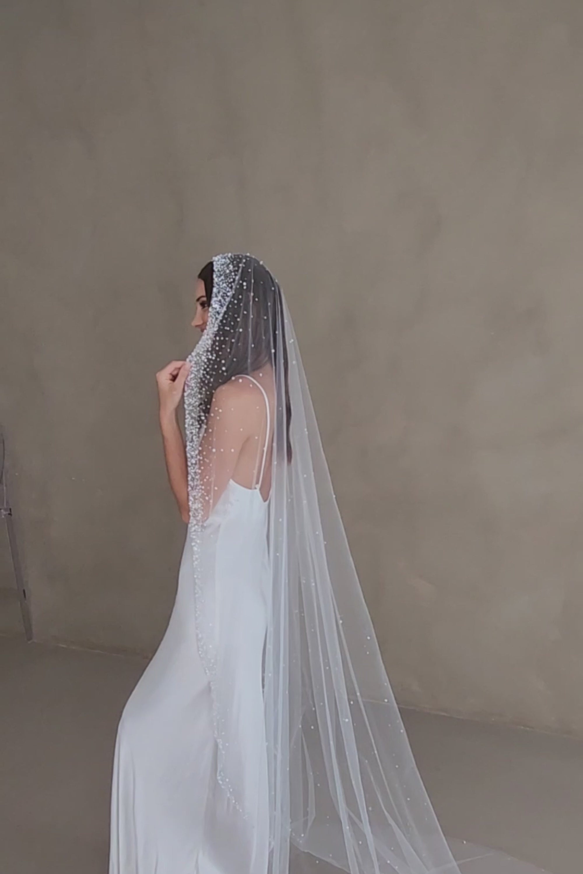 Model wears a mantilla wedding veil, one tier veil with beads and sequins.