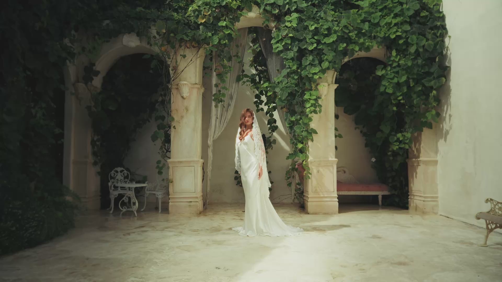 Full length front facing bride wearing long lace trimmed veil in Tuscan style setting