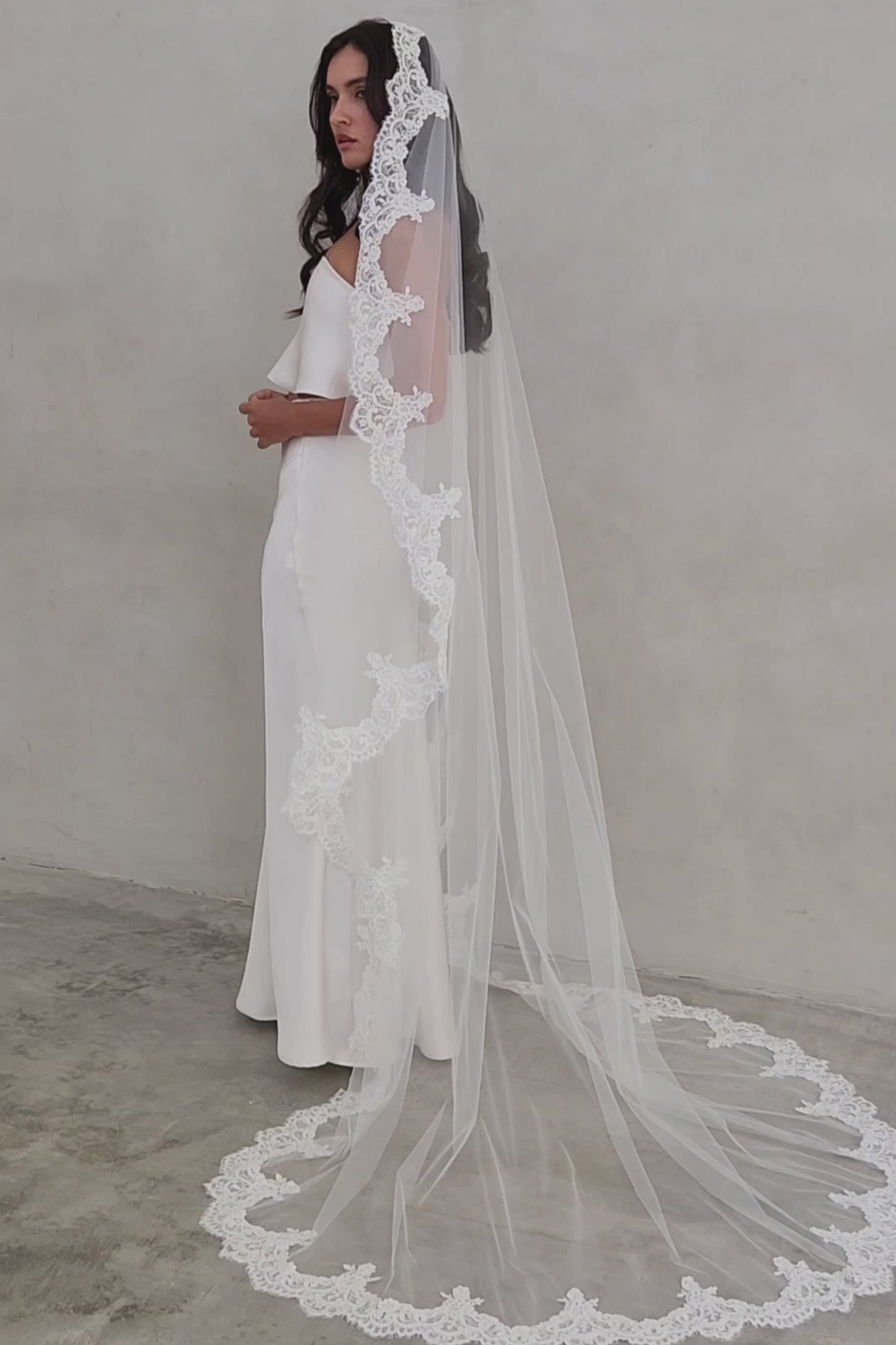 Full length shot showing romantic drape of long bridal veil trimmed with scalloped lace