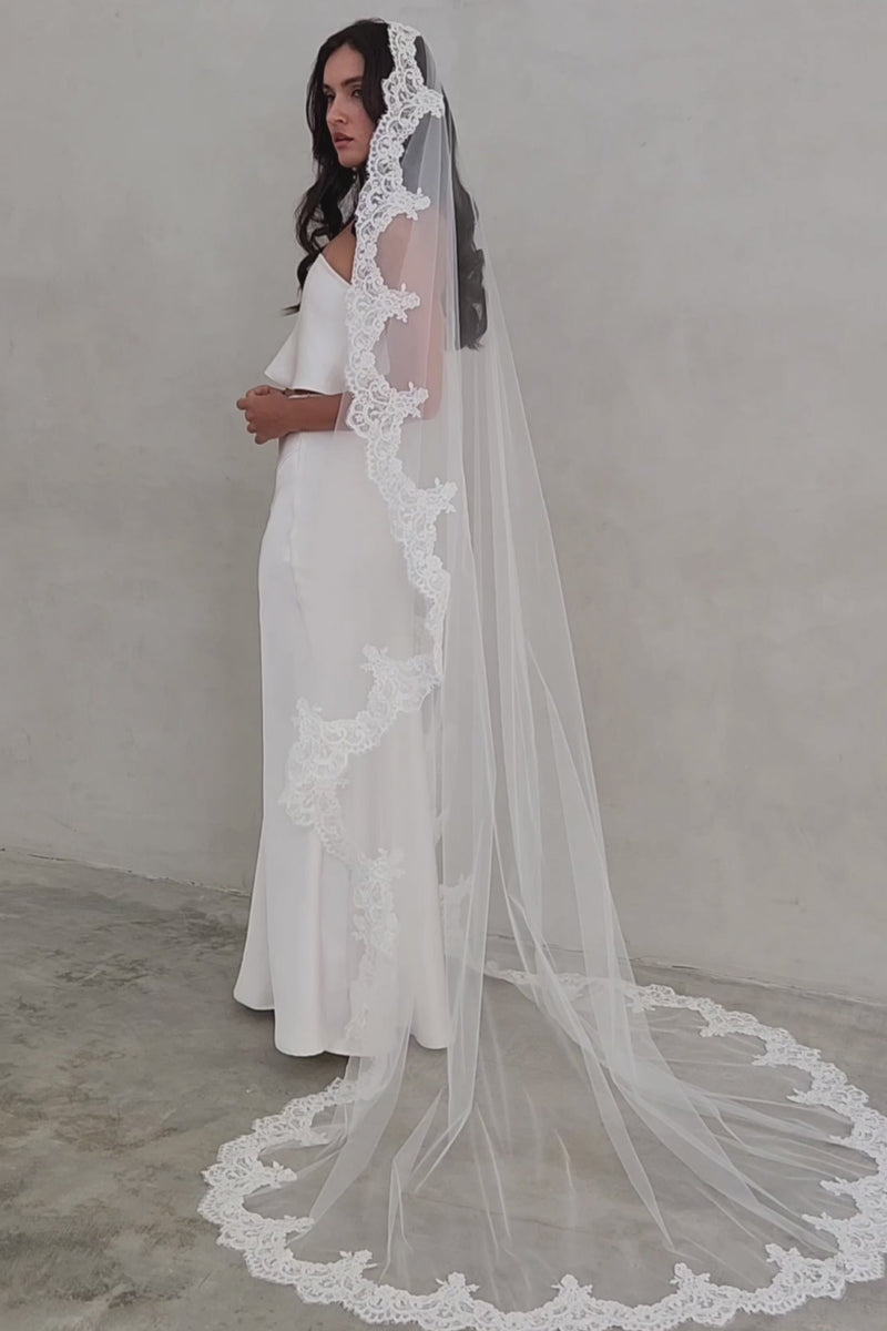 Full length shot showing romantic drape of long bridal veil trimmed with scalloped lace