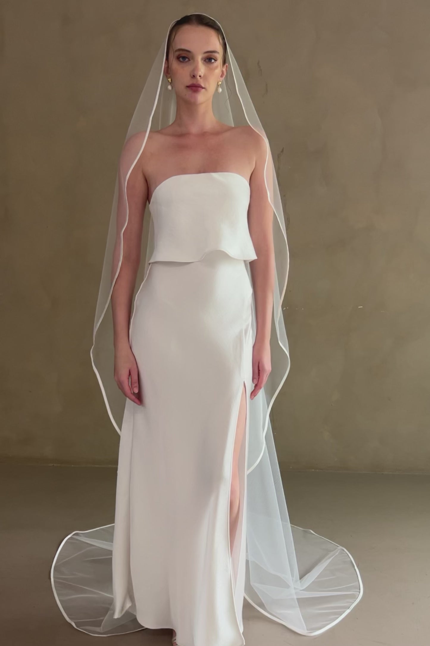 Model wears one-tier satin edge wedding veil