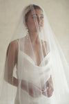 A model wearing a wedding veil over her face