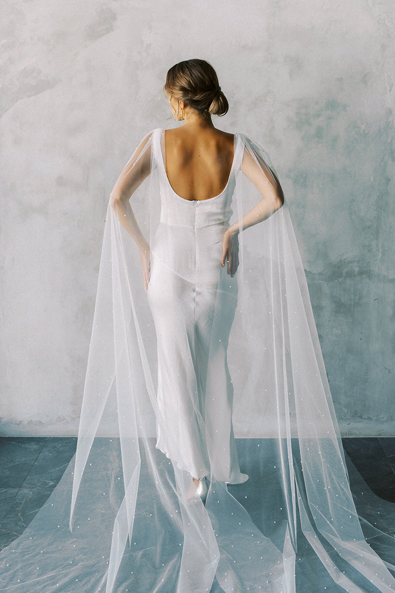 Model wears a detachable tulle wings with pearls