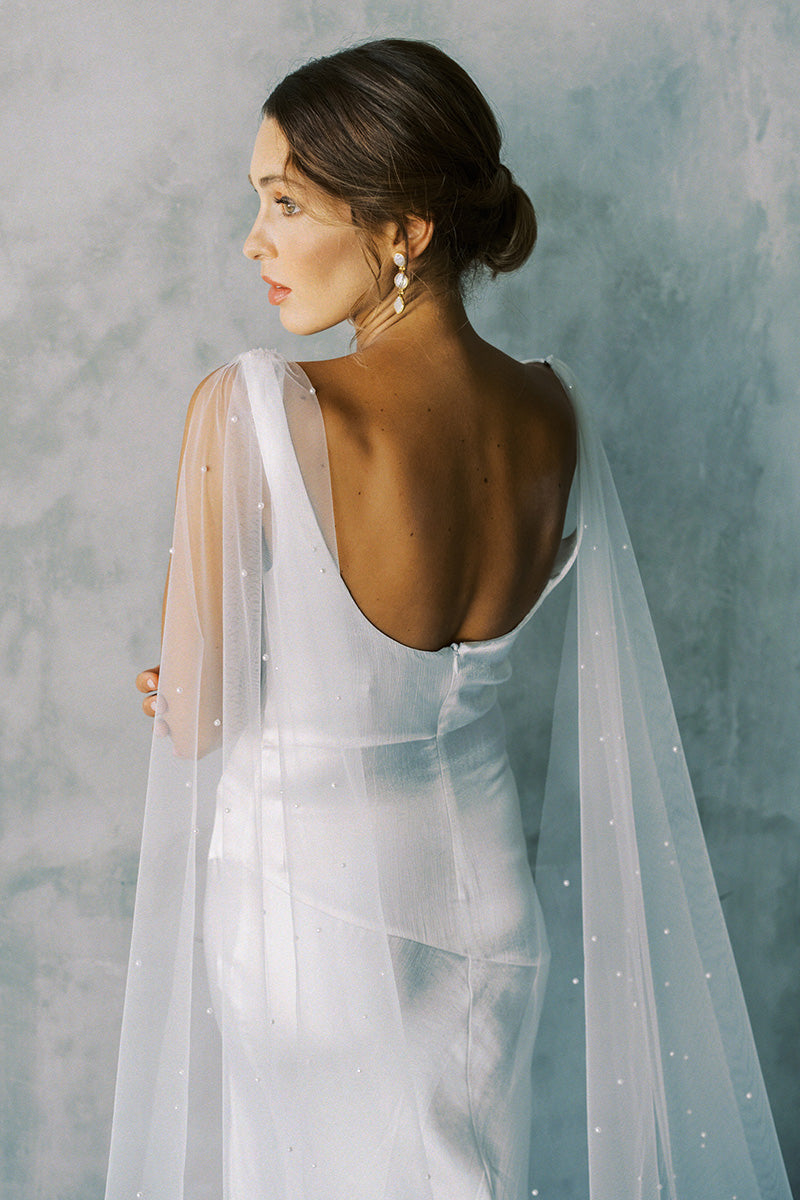 Model wears a detachable tulle wings with pearls