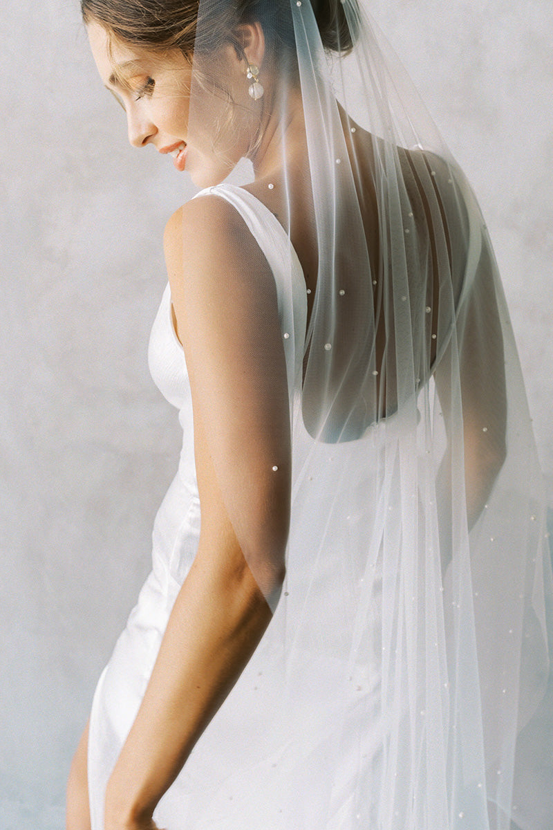 A model wearing a one tier wedding veil with pearls