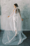 A model wearing a one tier wedding veil with pearls in chapel length