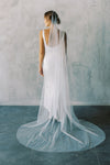 A model wearing a one tier wedding veil with pearls in chapel length