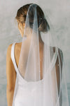 A model wearing a one tier wedding veil with pearls