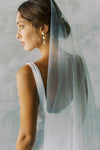 A model wearing a one tier wedding veil with pearls