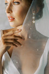 A model wearing a two tier wedding veil with pearls