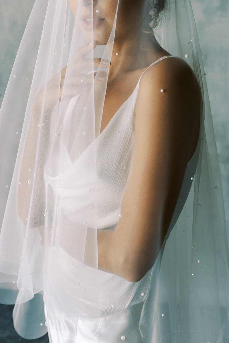 A model wearing a drop veil with pearls