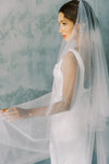A model wearing a two tier wedding veil with pearls