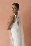 A model wearing CELINE I, a lace Mantilla wedding veil by Madame Tulle