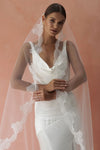 A model wearing CELINE I, a lace Mantilla wedding veil by Madame Tulle