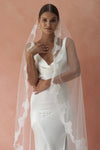 A model wearing CELINE I, a lace Mantilla wedding veil by Madame Tulle