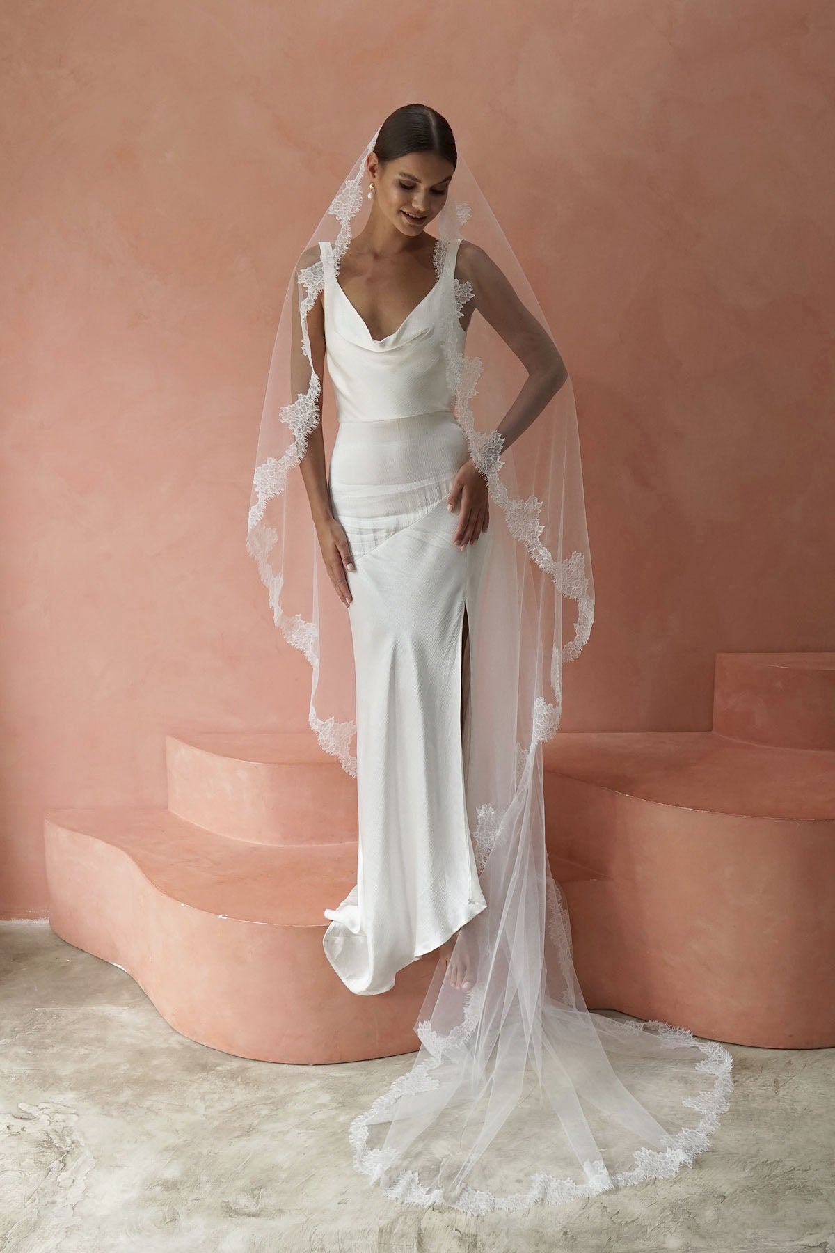 A model wearing CELINE I, a lace Mantilla wedding veil by Madame Tulle