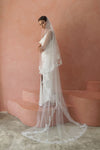 A model wearing CELINE II, a two tier lace wedding veil in cathedral length by Madame Tulle