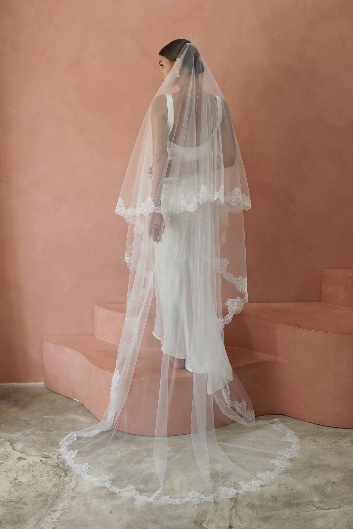 A model wearing CELINE II, a two tier lace wedding veil by Madame Tulle