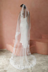 A model wearing CHANTELLE I, a lace Mantilla veil in cathedral length by Madame Tulle