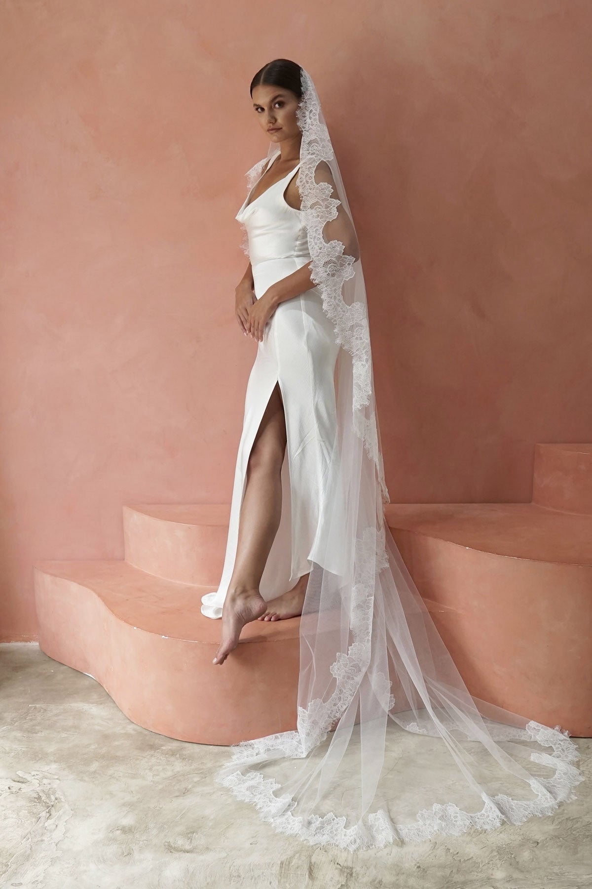 A model wearing CHANTELLE I, a lace Mantilla veil in cathedral length by Madame Tulle