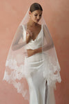 A model wearing CHANTELLE II, a two tier lace wedding veil in cathedral length by Madame Tulle