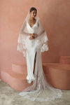 A model wearing CHANTELLE II, a two tier lace wedding veil in cathedral length by Madame Tulle