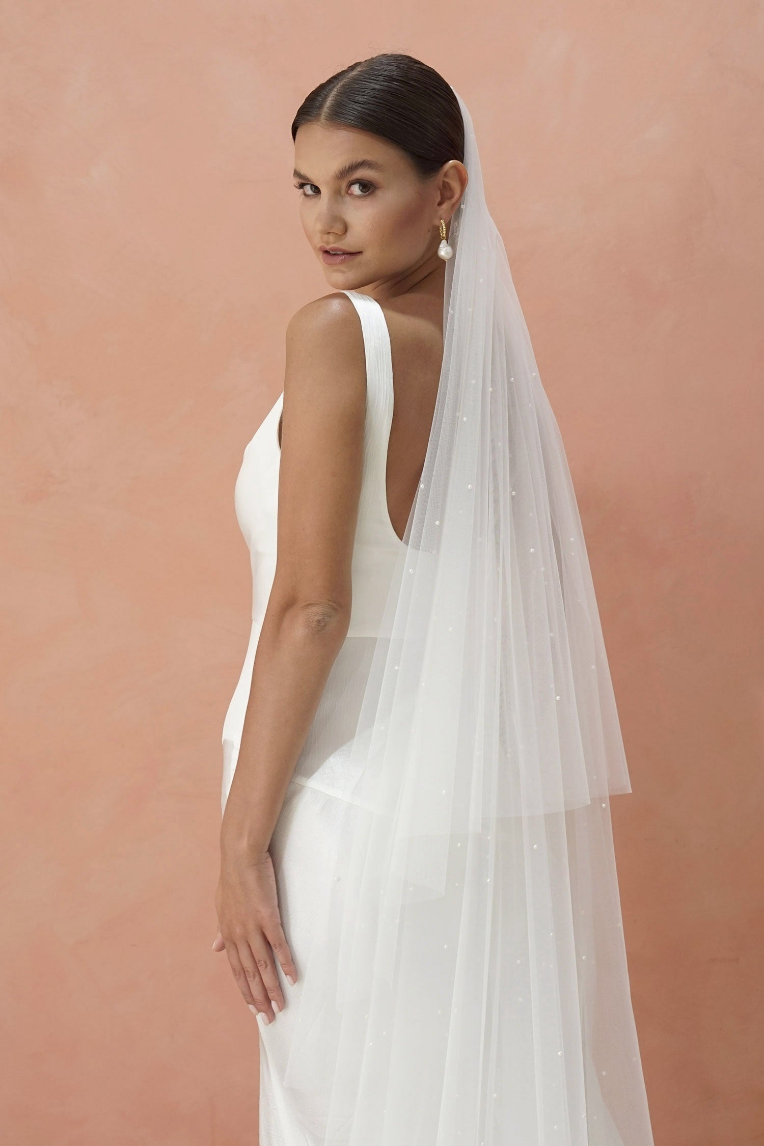 A model wearing two tier wedding veil with small pearls, drop veil