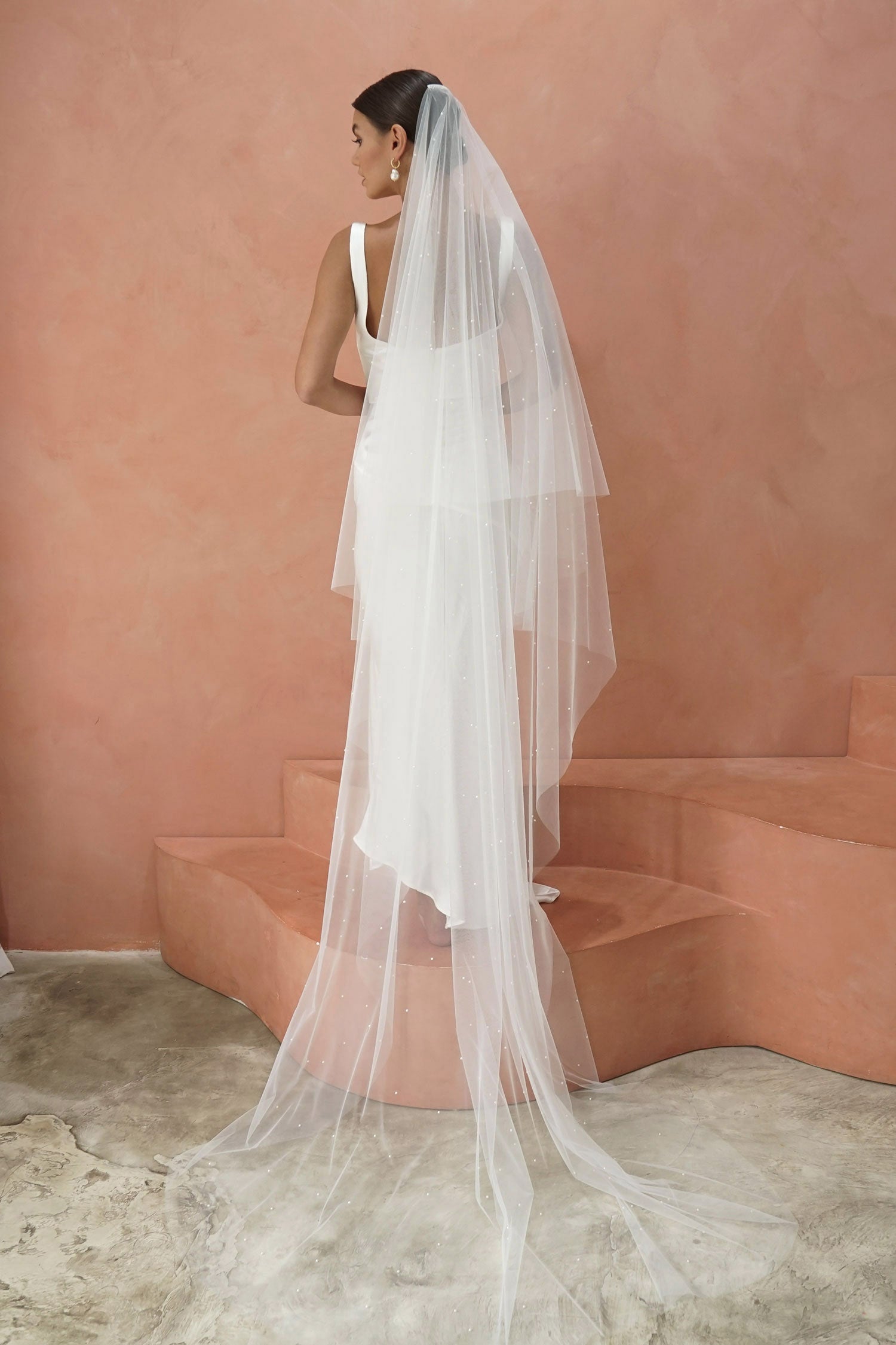 A model wearing two tier wedding veil with small pearls, drop veil