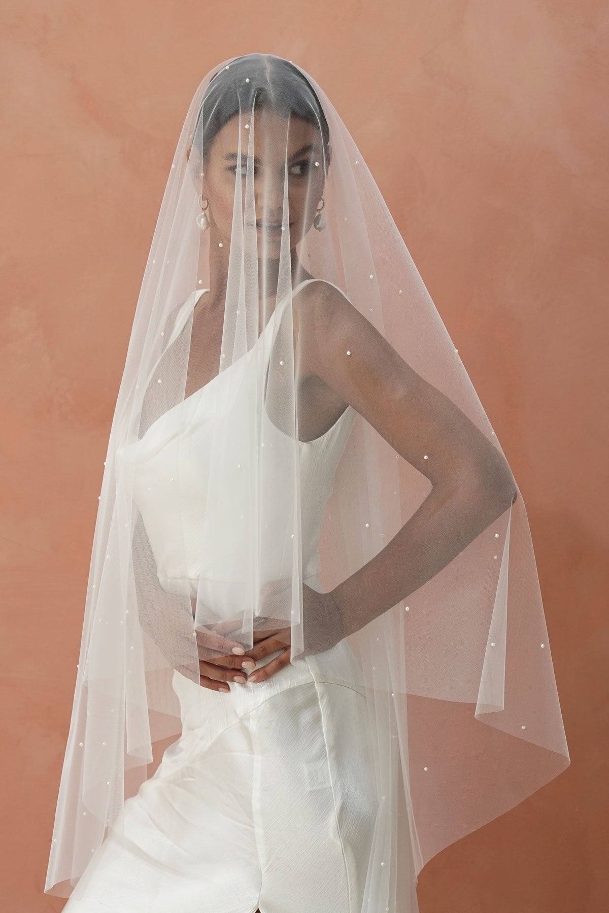 A model wearing the CHLOE two tier wedding veil with small pearls