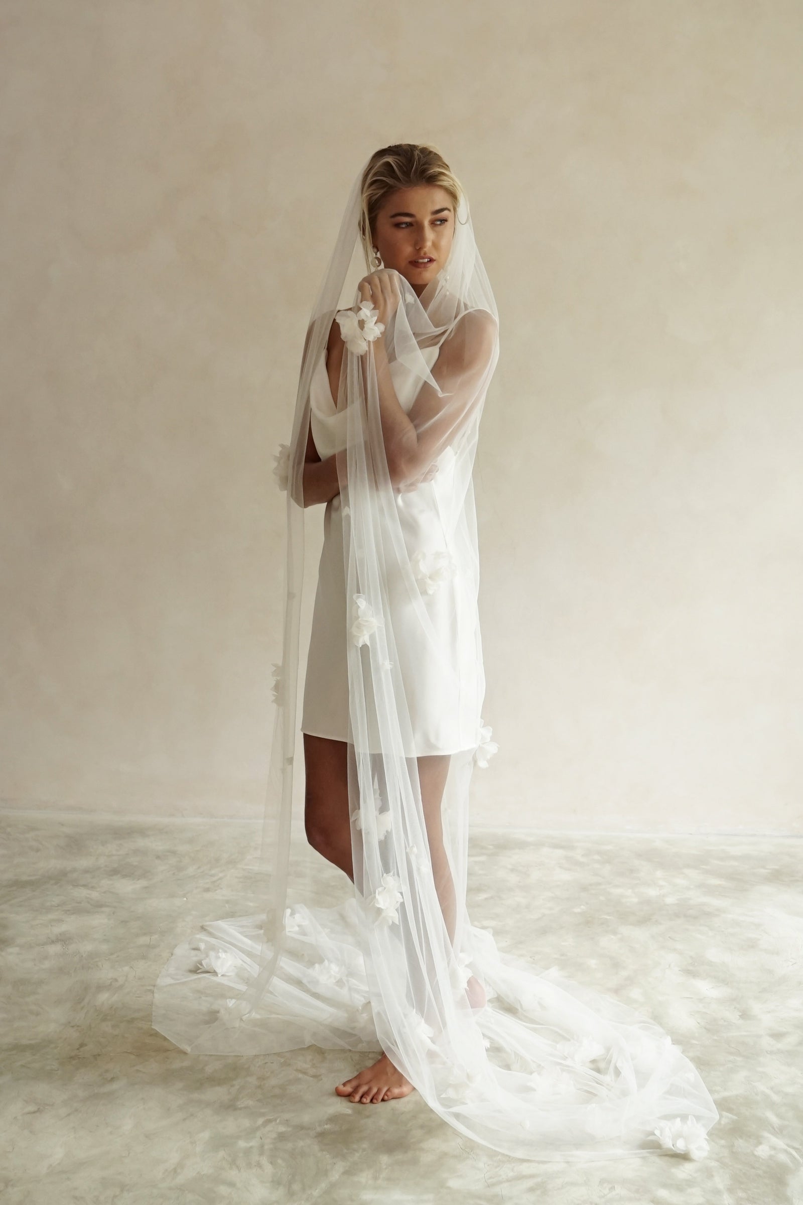 model wears wedding veil with fabric flowers, floral veil