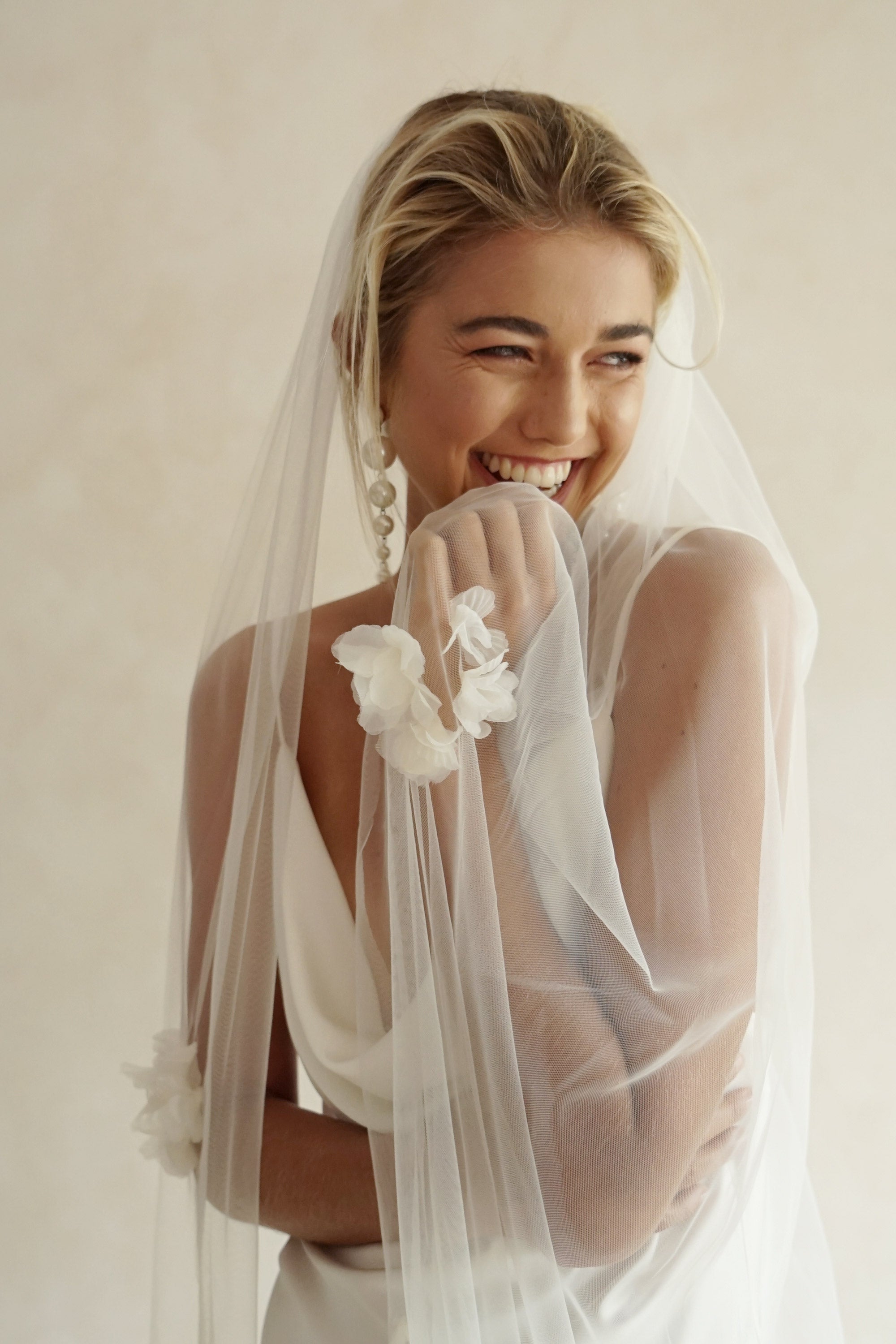 model wears wedding veil with fabric flowers, floral veil