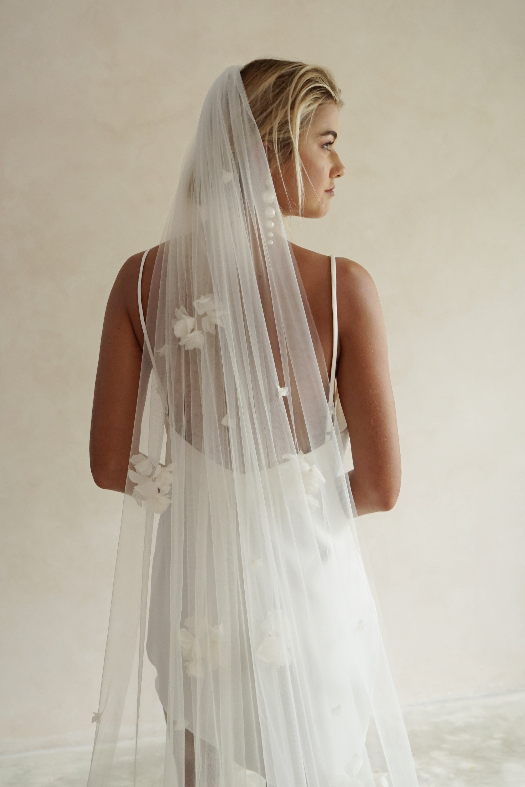 model wears wedding veil with fabric flowers, floral veil