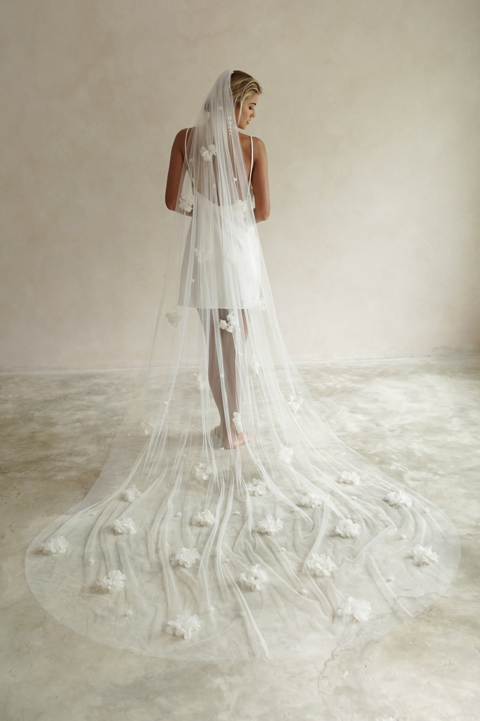 model wears wedding veil with fabric flowers, floral veil