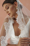 A model wearing COLETTE I, a lace Mantilla veil