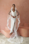 A model wearing COLETTE I, a lace Mantilla one tier veil