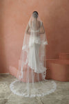 A model wearing COLETTE II, a two tier lace wedding veil by Madame Tulle