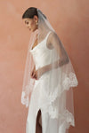 A model wearing COLETTE II, a two tier lace wedding veil by Madame Tulle