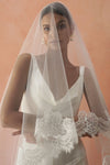 A model wearing COLETTE II, a two tier lace wedding veil by Madame Tulle