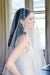 A model wearing MARIBEL II two tier pearl wedding veil by Madame Tulle