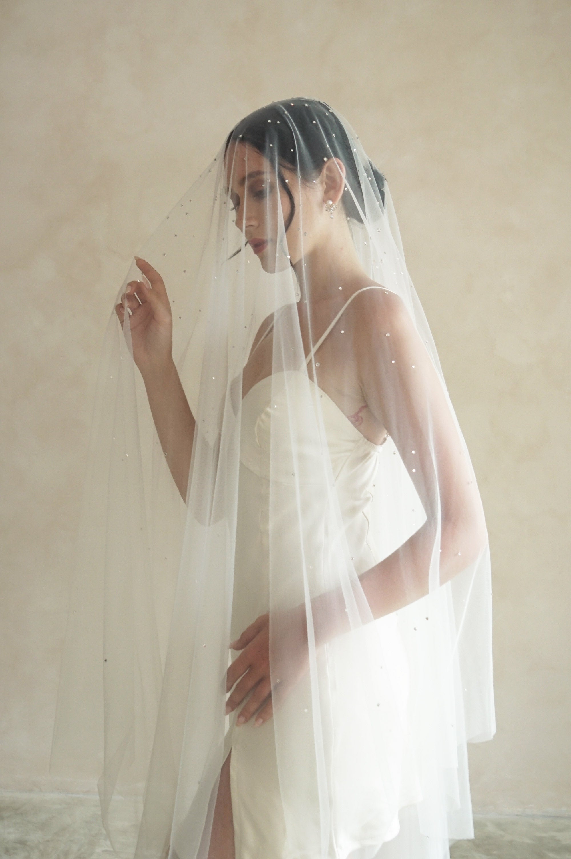 A model wearing a two tier wedding veil with crystals by Madame Tulle